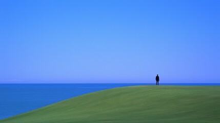 Fototapeta premium Solitary Figure Contemplating Ocean View Serene Coastal Landscape Photography