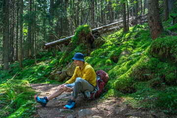 Man is Travelling with Backpack and has Problems with Sprained Ankle in the Forest