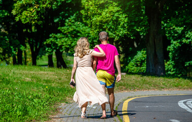 Obraz premium A man and a woman walk in a summer park 