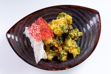 Deep-Fried Vegetables on a Plate Against a White Background
