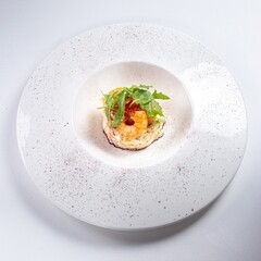 Arugula Salad with Shrimp on a White Plate Against a White Background