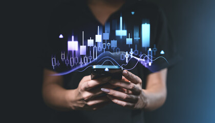Financial chart and candlestick graph overlay on smartphone, held by person in dark background.