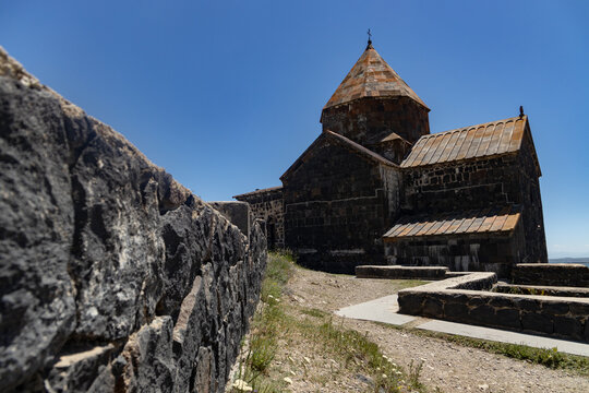 Sevanavank monastery stands majestically with its ancient stone architecture under a vibrant blue sky in Armenia.