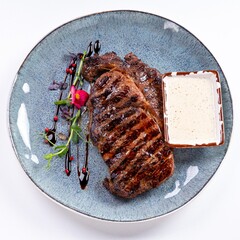 Huge Juicy Steak with Sauce on a Plate on a White Background