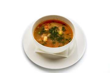 A bowl of soup with a white plate and a napkin