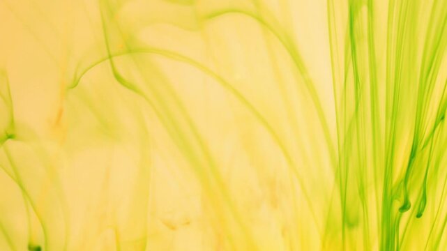 Green ink breaks up in water creating abstract structures, inky background