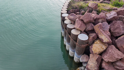 A serene lake bordered by a stone revetment highlights erosion control and conservation efforts near natural water bodies