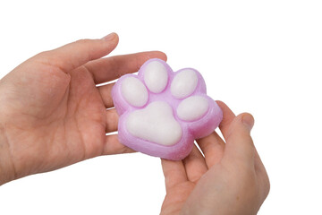 Pink toy cat paw in the hand isolated on a white background. Decompression squeeze toy.