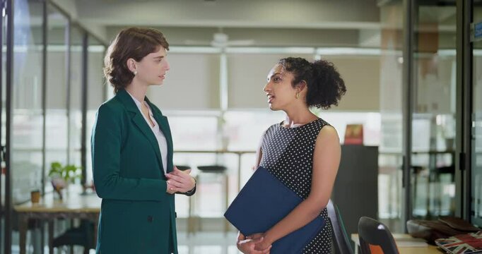 Young adult happy gen z diverse ceo woman lady talk share ideas plan discuss work day task indoor job office place teen female girl agent boss intern staff hold file folder give career advice client