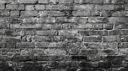 Fototapeta premium a black and white brick wall with a grungy texture The bricks are arranged in a pattern, giving the wall a unique and aged look The texture of the bricks is rough