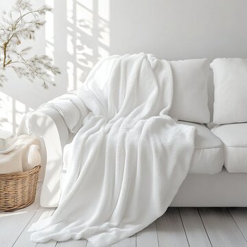White sofa with blanket in Christmas-themed room.