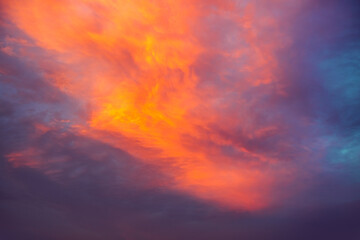 Obraz premium A breathtaking view of the evening sky with clouds shining red-orange shades.