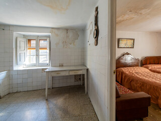 Exploring an abandoned house with damaged walls and vintage furniture