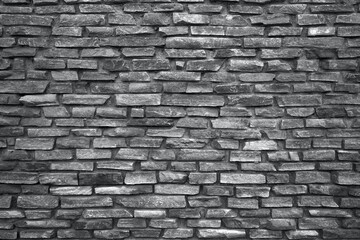 Obraz premium Rough stone wall made of ceramic tiles of different sizes and colors: black and white texture.