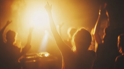 Crowd of people at a concert with raised hands enjoying the music and light show.