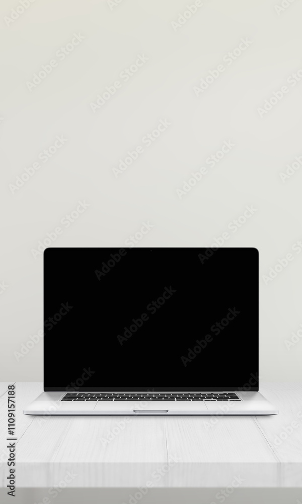 Poster laptop with a blank screen on a desk against a white wall, ideal for mockup presentations of website