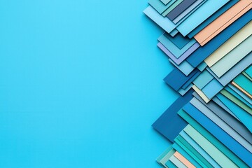 Fototapeta premium Material science and strength, A vibrant arrangement of colorful paper strips on a blue background, showcasing various shades of blue and pastel colors.