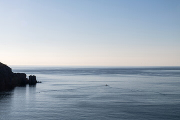 cliff silhouette and fishing boat on the sea
