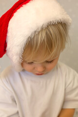 a young boy wearing a santa hat that says santa