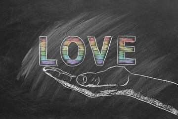 A chalkboard design features the word LOVE in rainbow letters, resting delicately on a sketched hand. LGBT, LGBTQIA rights and gender equality concept. Pride month. Declaration of love