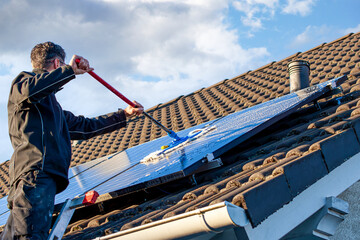 man holding mop cleaning solar panels. cleaning of solar modules with water. close-up of solar...