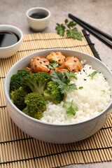 Tasty rice with broccoli and chicken served on grey table, closeup