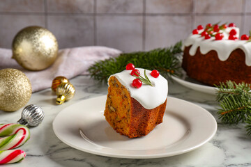 Piece of traditional classic Christmas cake and decor on white marble table