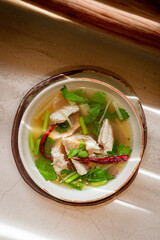 Top view of boiled fish with ginger and dried chili in bowl, Thai dish