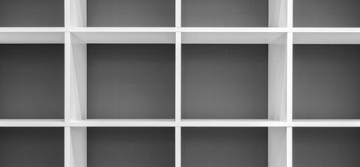 Obraz premium A white shelf with a red background. The shelf is empty.