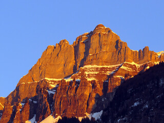 Fototapeta premium Steep rocky peaks of the Churfirsten mountain range, above Lake Walensee and the Swiss town of Walenstadtberg (Die steilen Felsgipfel der Churfirstengruppe oberhalb des Walensees, Schweiz)