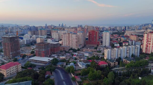Drone footage of Baku city with buildings at sunset