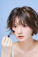 Obraz premium メイクアップする若い女性