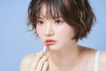 Naklejka premium メイクアップする若い女性