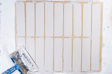Filling and leveling of decorative brick molds with spatula.