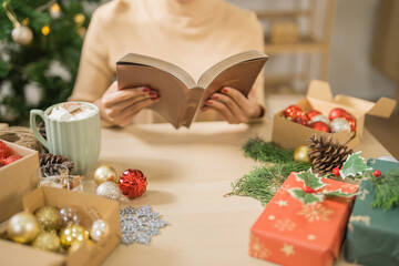 Happy woman  reading book celebrating christmas at home relax Xmas holiday