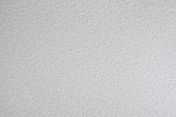 A white wall with a textured surface. The wall is covered in a pattern of small bumps white gray texture background for template, page or web banner