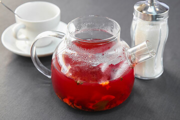 Red hot fruit tea brewed in a glass teapot