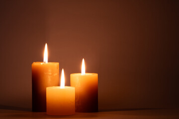Burning candles on dark background.