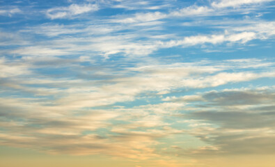 Obraz premium A beautiful sky tinted by the sun leaving vibrant shades of gold, pink, blue and multicolored. Clouds in the twilight evening and morning sky. Cloudy sky background in the evening, and during the day.