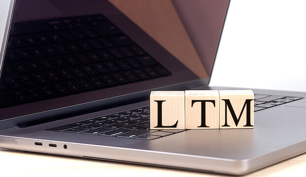 Wooden blocks with the letters LTM on a laptop keyboard