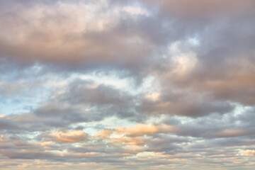 A beautiful sky tinted by the sun leaving vibrant shades of gold, pink, blue and multicolored. Clouds in the twilight evening and morning sky. Cloudy sky background in the evening, and during the day.