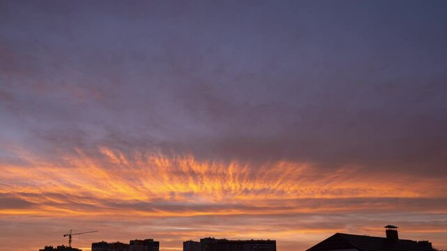 Time lapse: dramatic sunrise sky over the city . City is slowly awakening, getting brighter. Early morning, summer, cityscape, urban and time lapse concept
