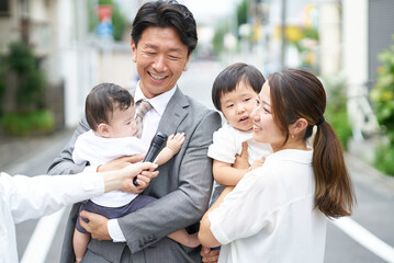 住宅街でインタビューを受ける家族