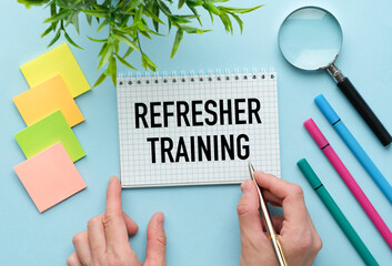 Refresher Training text on paper on blue background. Business Concept.