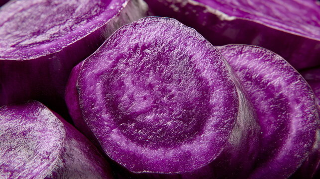 A macro shot of a purple ube yam, sliced to show its vivid violet color inside