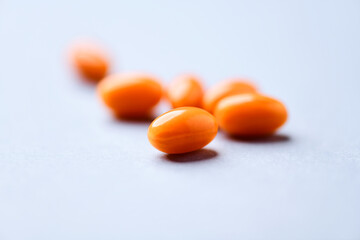 Coenzyme Q10 capsules. Antioxidants. Concept for a healthy dietary supplementation. Bright paper background. Soft focus. Close up. Copy space.	