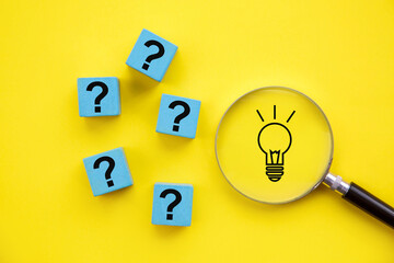 Light bulb in magnifying glass and question mark sign; Concept of solving problem and creative...