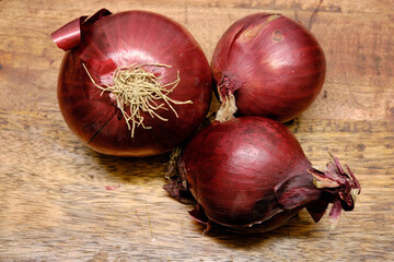 Onions lying on a wooden log. Onions are a vegetable with great nutritional and medicinal properties.