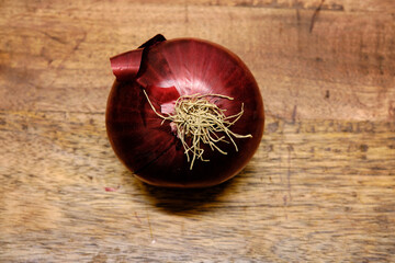 Onions lying on a wooden log. Onions are a vegetable with great nutritional and medicinal properties.