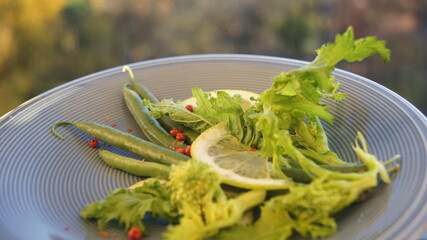 Detox lunch green beans with lemon, pink pepper, turnip flowers, green vegetables, healthy food,...